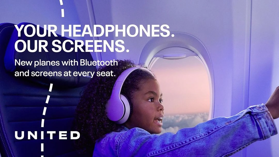 Young girl wearing headphones on airplane, seated next to window with clouds visible, promotional shot for airline with text overlay.