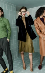 Three models wearing vintage-inspired autumn clothing standing in front of a pale green tiled wall.