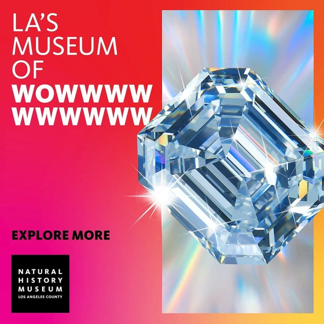 Advertisement for LA's Museum of Wowwww, featuring a large clear gemstone with reflected light against a split red and yellow background.
