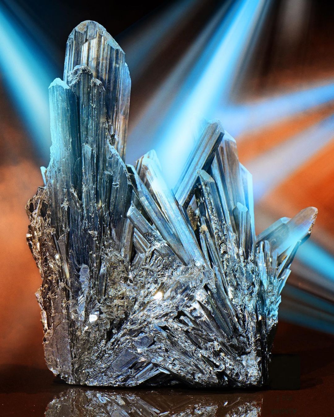 Close-up of a cluster of black tourmaline crystals with a radiant blue light emanating from behind, emphasizing the mineral's texture.