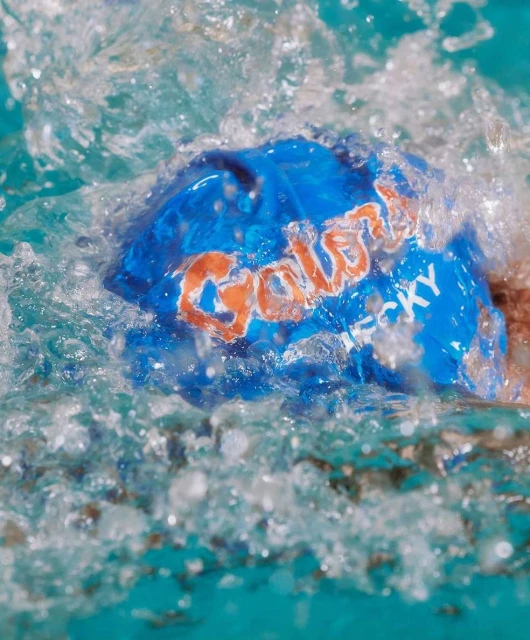 Close-up of a blue Galaxy chocolate wrapper submerged in water, with water droplets splashing around the brand name.