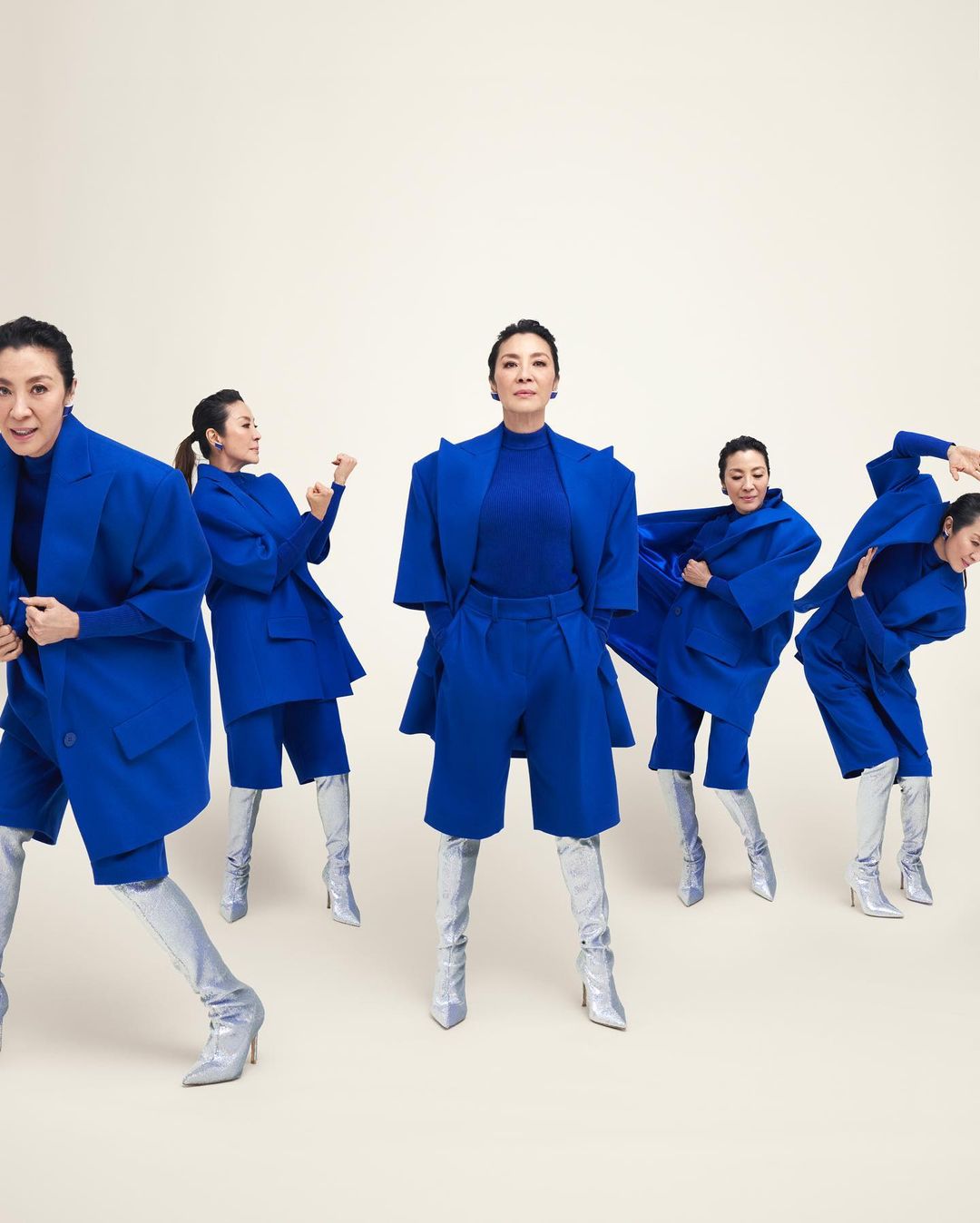 Multiple images of an adult woman wearing a blue jacket and short set with silver high heel boots against a neutral background.
