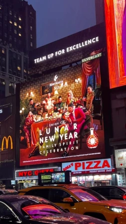 Large digital billboard in Times Square displays a Remy Martin ad featuring a group of people at a table, promoting Lunar New Year.