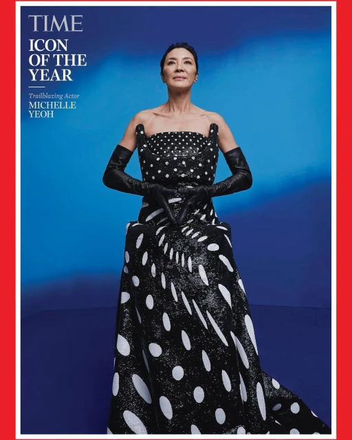 Michelle Yeoh on the cover of TIME's 'Icon of the Year' issue, wearing a black-and-white polka-dot dress and long black gloves, against a blue background.
