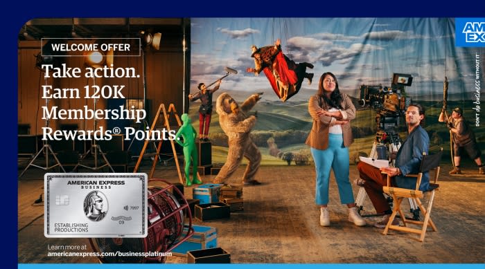 American Express business card ad with actors and crew on a film set. A woman and man are in foreground, with fantasy characters.