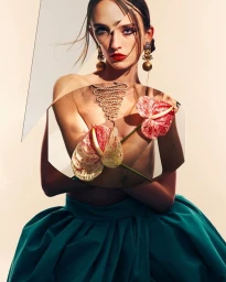 Model in green skirt holding two anthurium flowers with geometric collage overlays photographed by Michelle Watt.