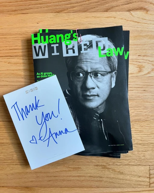 Wired magazine cover featuring Jensen Huang with a thank you note, and paperclip on a light brown wooden surface.
