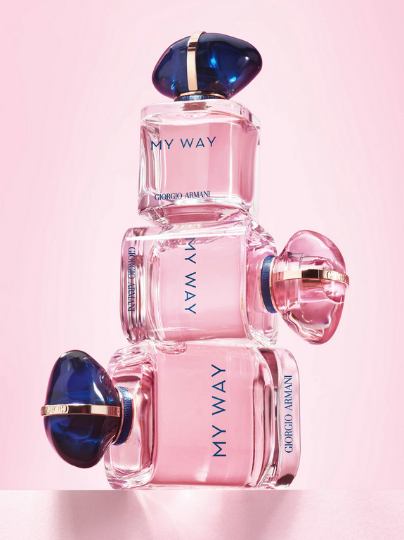 Three Giorgio Armani 'My Way' perfume bottles stacked on a pink surface against a pink gradient background in a beauty product shot.