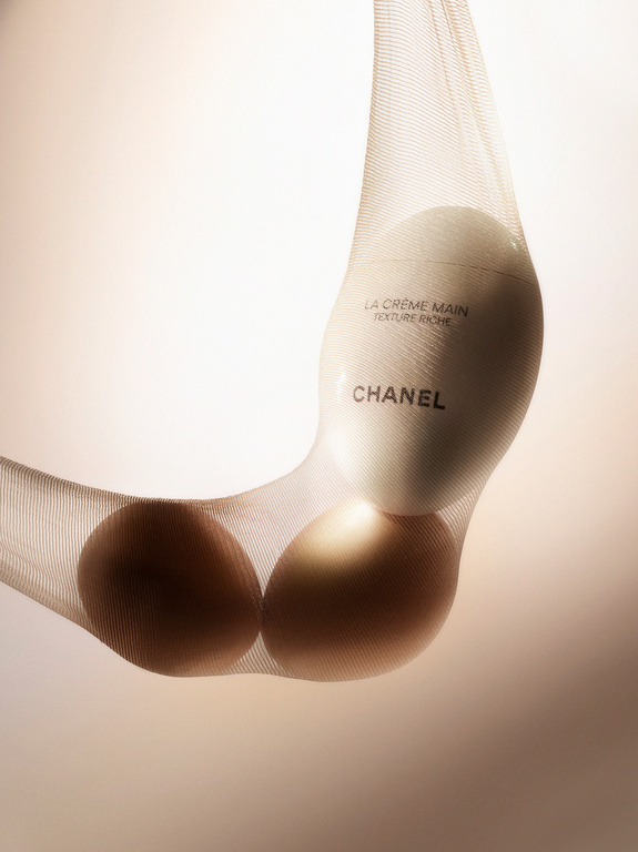 Chanel hand cream in a sheer stocking with two brown eggs against a light background, showcasing beauty and still life.