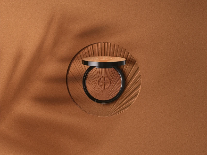Close-up of bronze face powder on a textured platform against a bronze background with soft lighting and shadow patterns.