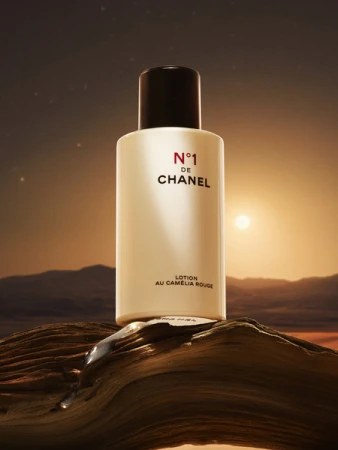 Chanel N°1 de Chanel lotion bottle stands on wood surface with sunset background, skincare, beauty product, and cosmetic photography.