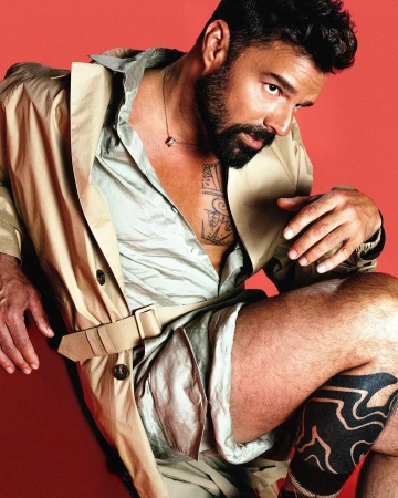 Portrait of a bearded man wearing an open beige trench coat against a red background by Callum Walker Hutchinson