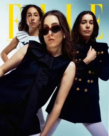 Three women posing in coordinated monochrome outfits against a gradient backdrop for an Elle magazine cover.