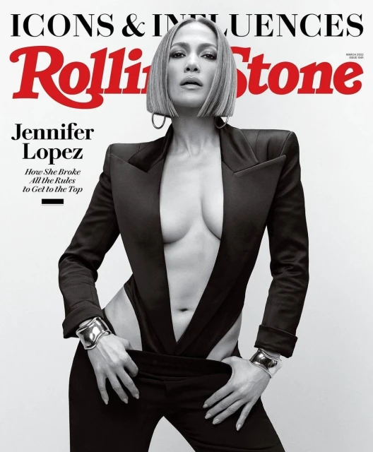 Jennifer Lopez poses on a Rolling Stone magazine cover. She wears a black suit with an open front and bracelets. The cover features the title.