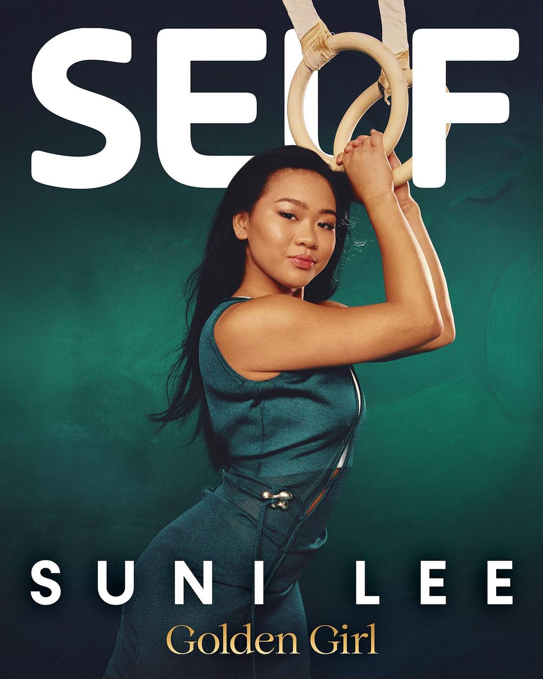 Portrait of gymnast Sunisa Lee on a magazine cover, posing with gymnastic rings, wearing a teal outfit, against a green backdrop.