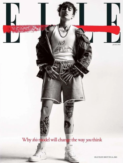 Magazine cover featuring a person in casual wear with visible tattoos, styled with a jacket, shorts, tank top, and sneakers against a clean backdrop.