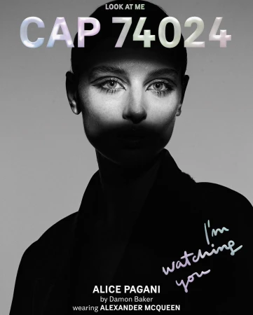 Black-and-white close-up of a model's face with dark eye makeup, paired with large stylized text and fashion branding on a light grey background.