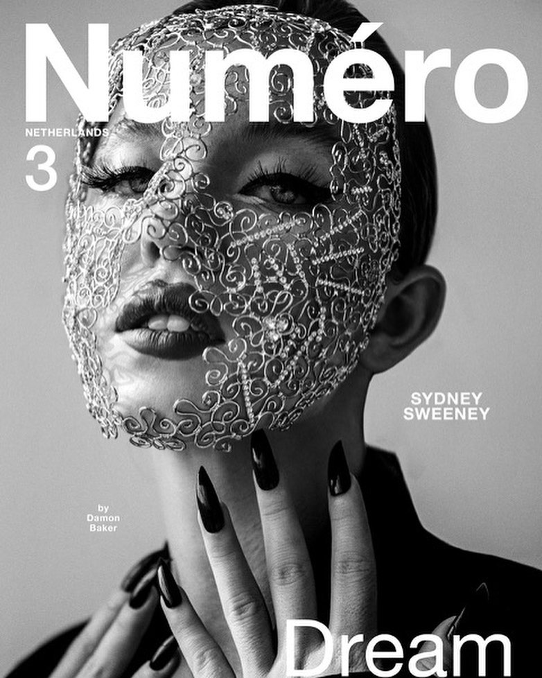 Black and white portrait of Sydney Sweeney on the cover of Numero Netherlands, wearing an ornate wire face mask with long black fingernails.