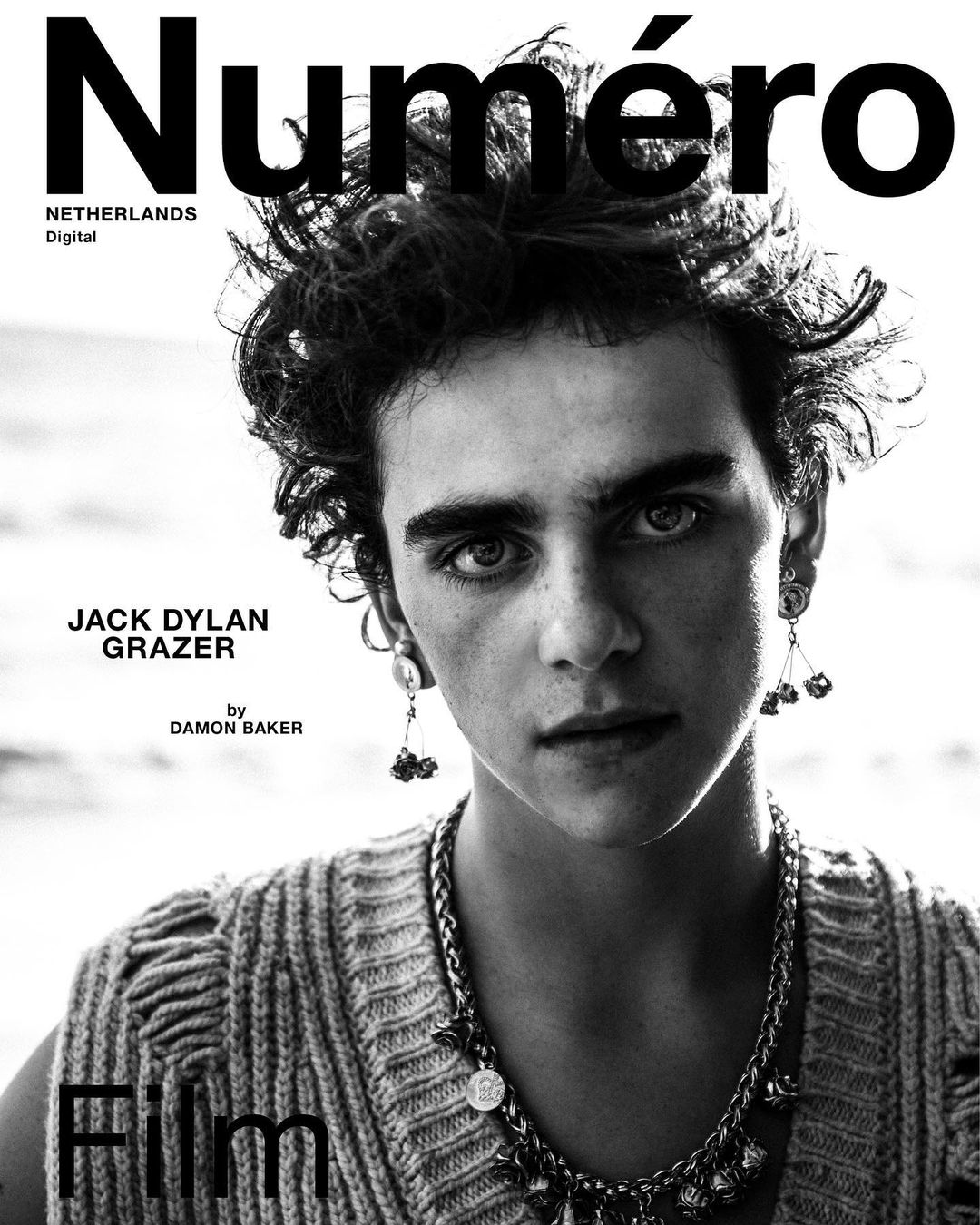 Black-and-white portrait of a young adult male with curly hair and a decorative necklace, featured on the cover of Numéro Netherlands Digital.