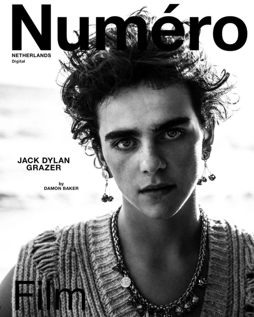 Black-and-white portrait of a young adult male with curly hair and a decorative necklace, featured on the cover of Numéro Netherlands Digital.