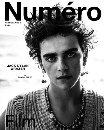 Black-and-white portrait of a young adult male with curly hair and a decorative necklace, featured on the cover of Numéro Netherlands Digital.