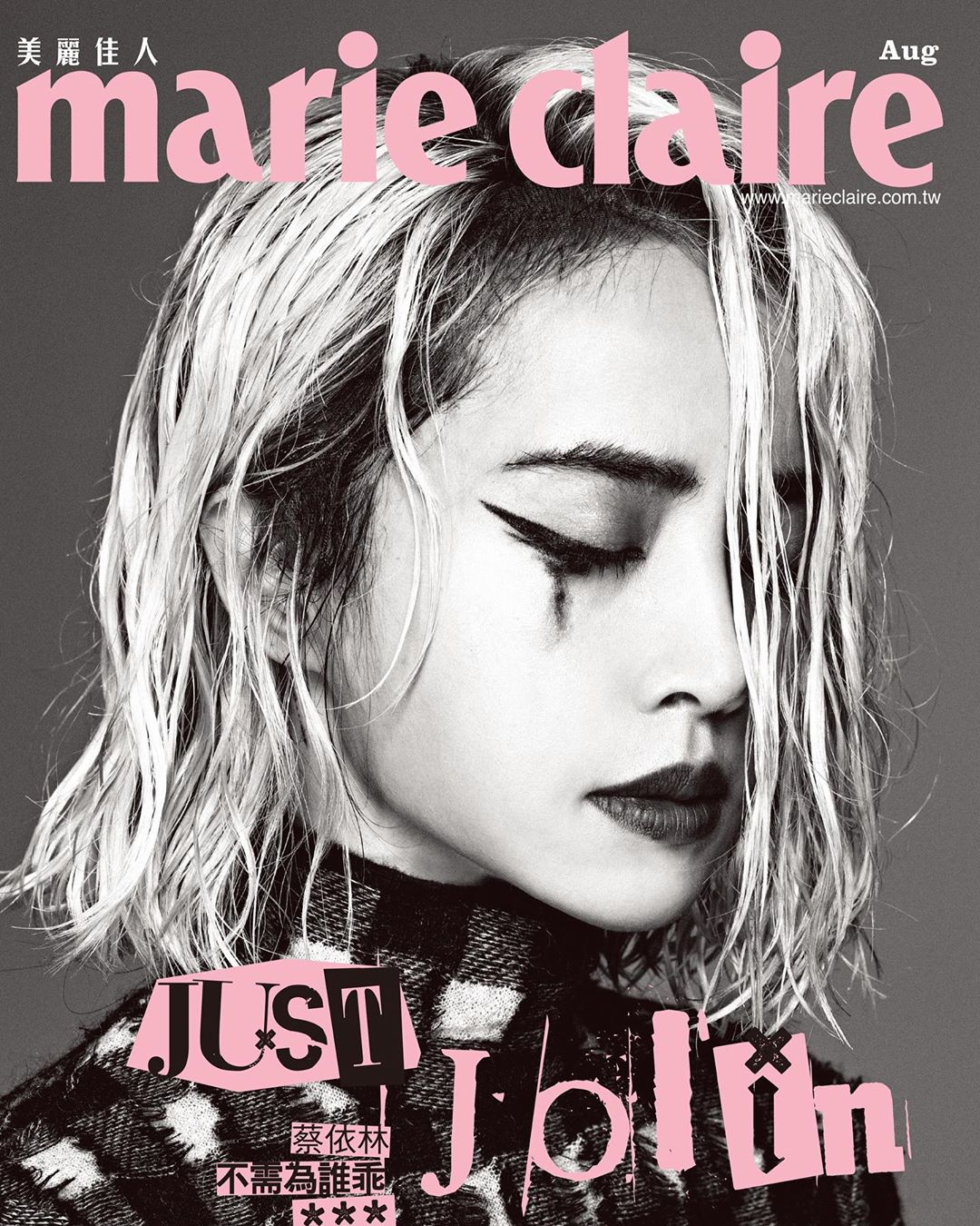 Marie Claire cover featuring a woman with dramatic eyeliner, styled blonde hair, and a patterned top, gazing downwards in a studio setting.