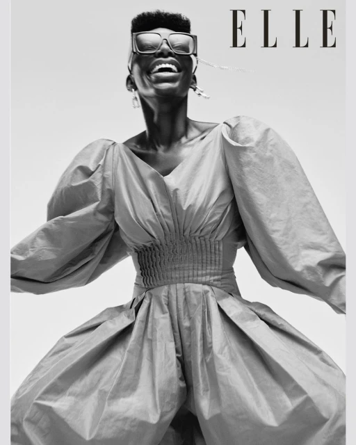 Elle magazine cover featuring an African American woman with short hair and large sunglasses wearing a voluminous blue dress smiling.