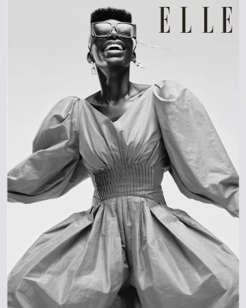 Elle magazine cover featuring an African American woman with short hair and large sunglasses wearing a voluminous blue dress smiling.