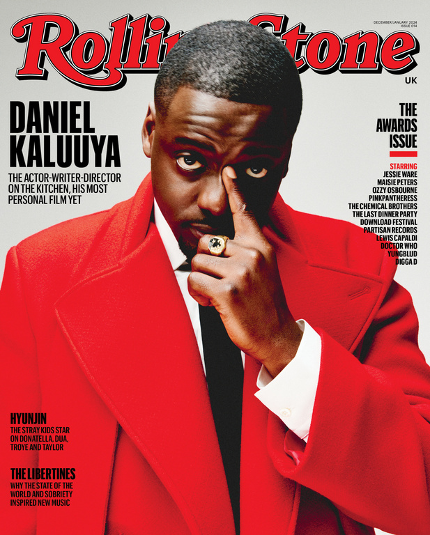 Daniel Kaluuya Rolling Stone cover. Close-up of actor in a red coat and black tie, posing with hand near his face and a ring.