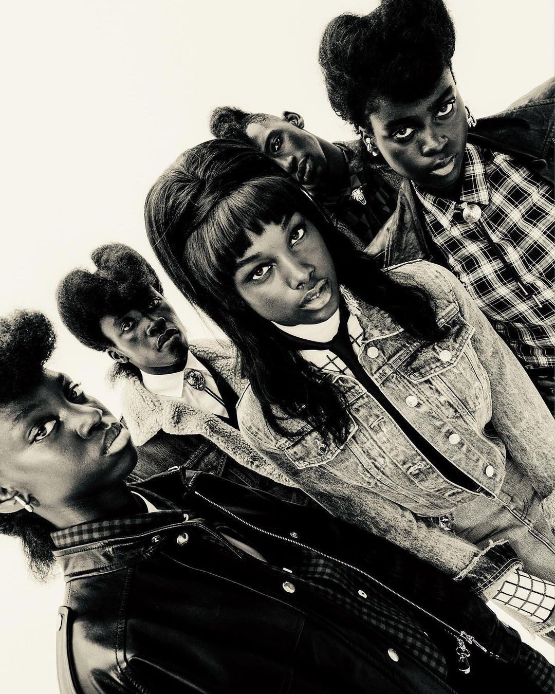 Group of five African American young adults in vintage 90s fashion, posing in a photo studio with medium shot, eye-level angle, and plain background.