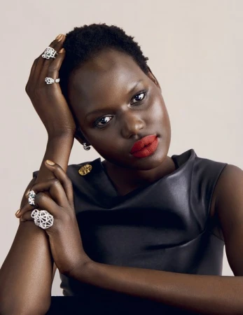 Black woman with short dark hair wearing a black dress and multiple diamond rings, photographed by Danny Kasirye.