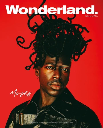 Portrait of a Black man with sculpted dreadlocks against a vibrant red background, photographed by Danny Kasirye.