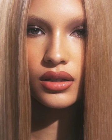 Close-up portrait of a woman with long straight blonde hair, glossy nude lips, and defined eye makeup by photographer Grace Scuitto.