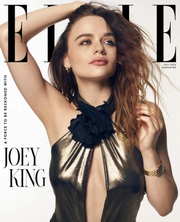 Joey King on the cover of Elle Singapore wearing a metallic halter top with a black fabric neck rosette against a white background