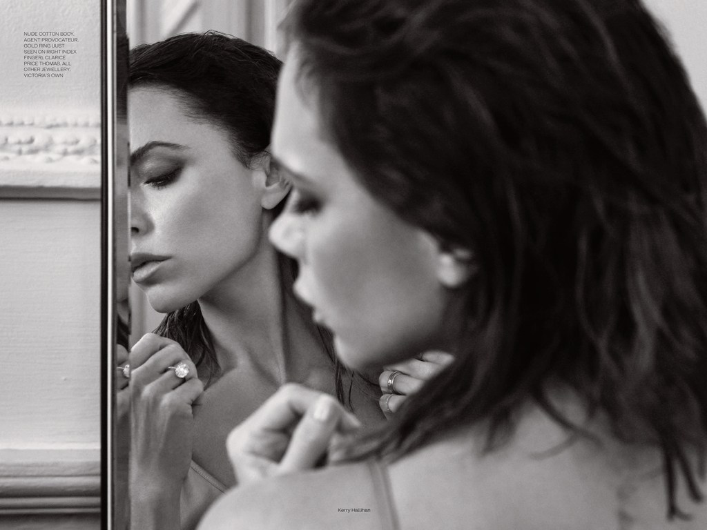 Monochrome fashion shot of a woman looking at her reflection, showcasing a ring, with soft lighting and focus on beauty.