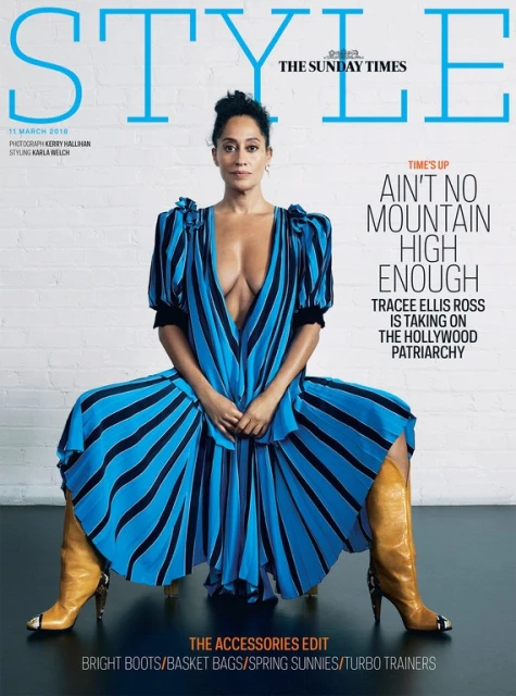 Tracee Ellis Ross poses on the cover of STYLE magazine wearing a striped blue dress and tan boots against a neutral backdrop.