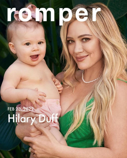 Hilary Duff and baby pictured in a magazine cover style photograph in front of tropical greenery with a fair skin tone.