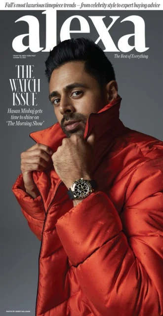 Magazine cover featuring Hasan Minhaj in an orange puffer jacket, posing indoors with a watch on his left wrist against a gray background.