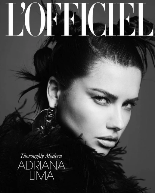 Close-up portrait of Adriana Lima in a black and white fashion magazine cover with feather details and statement earrings.