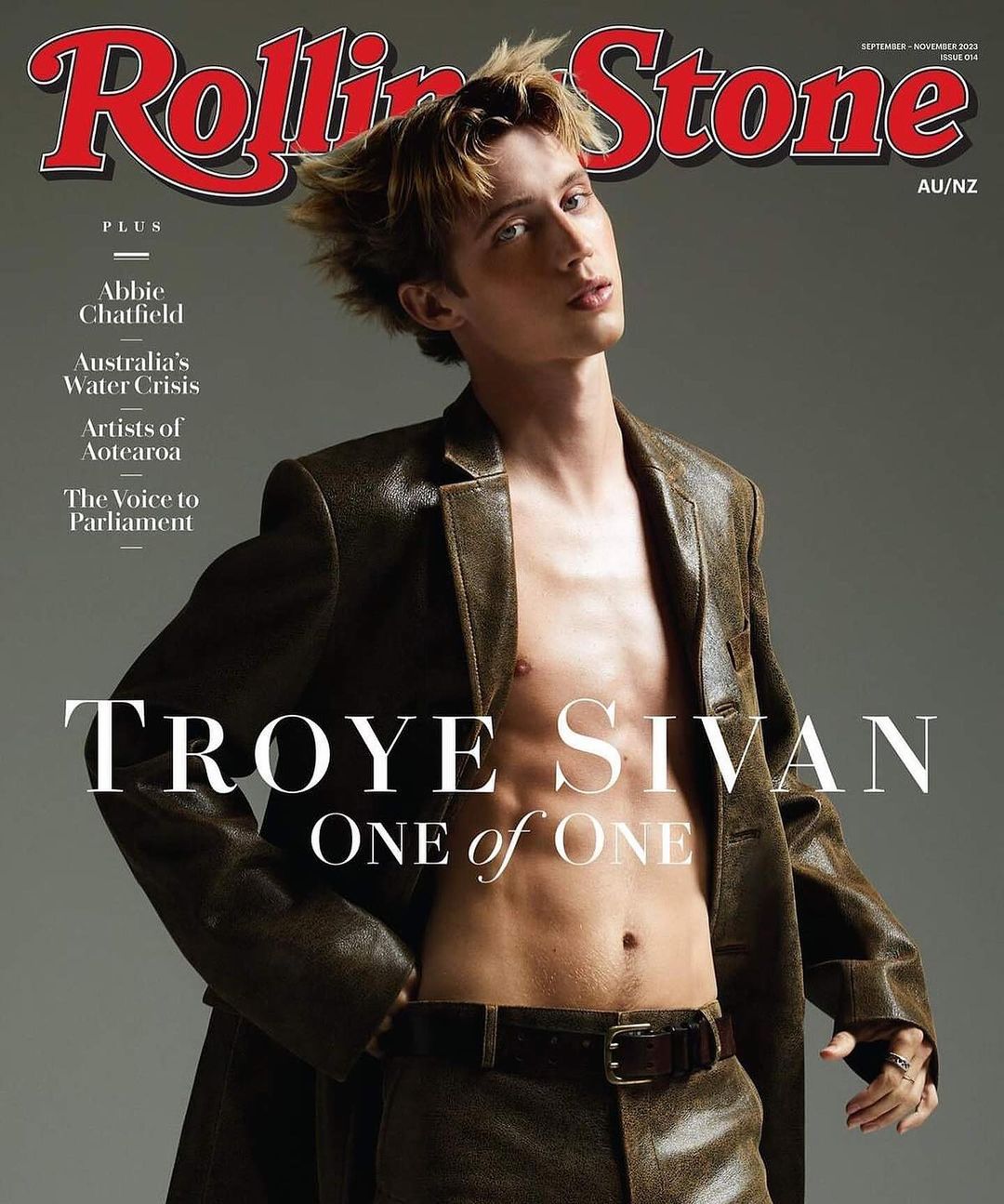 Rolling Stone magazine cover featuring Troye Sivan in a leather jacket and pants, posing shirtless against a grey backdrop with bold magazine text.