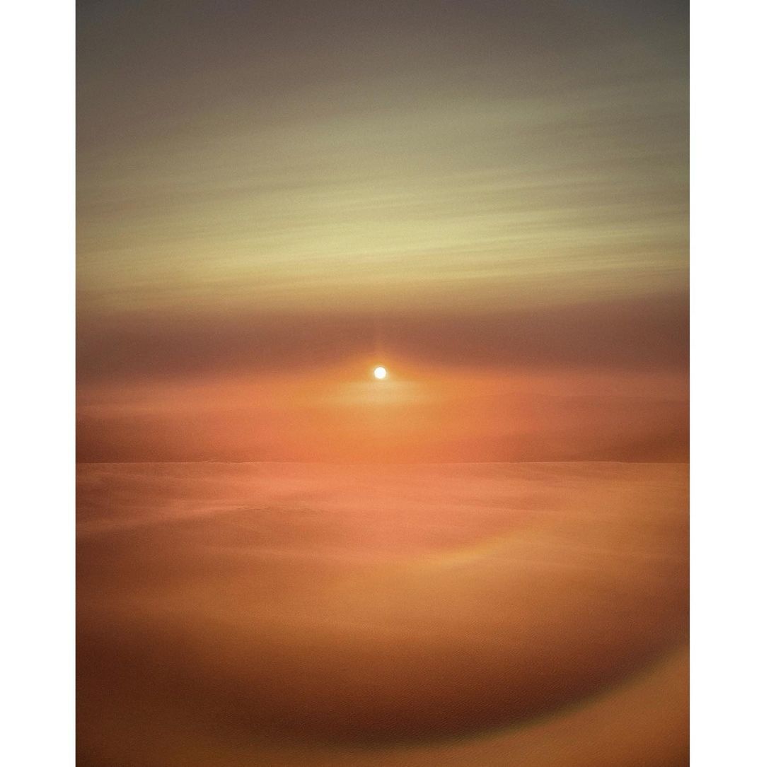 Vibrant orange sunset over the ocean horizon, reflecting on the calm water in a serene seascape.