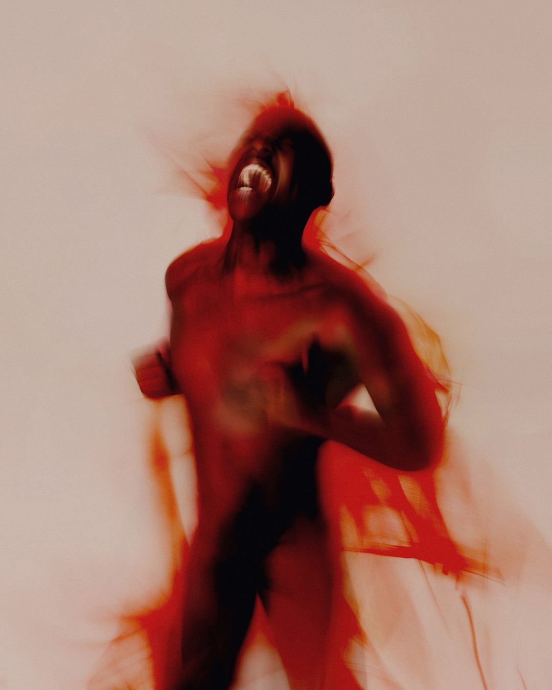 An artistic, blurred photograph presents a dark-skinned adult in motion, their mouth wide open in an apparent shout against a peach background.