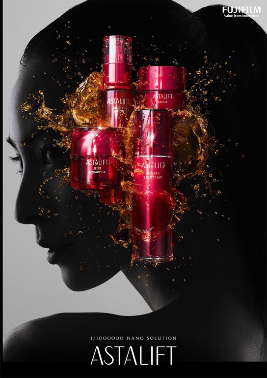 Cosmetic product still life with woman's profile in the background. Beauty products, gold liquid, and a female silhouette in shadow.