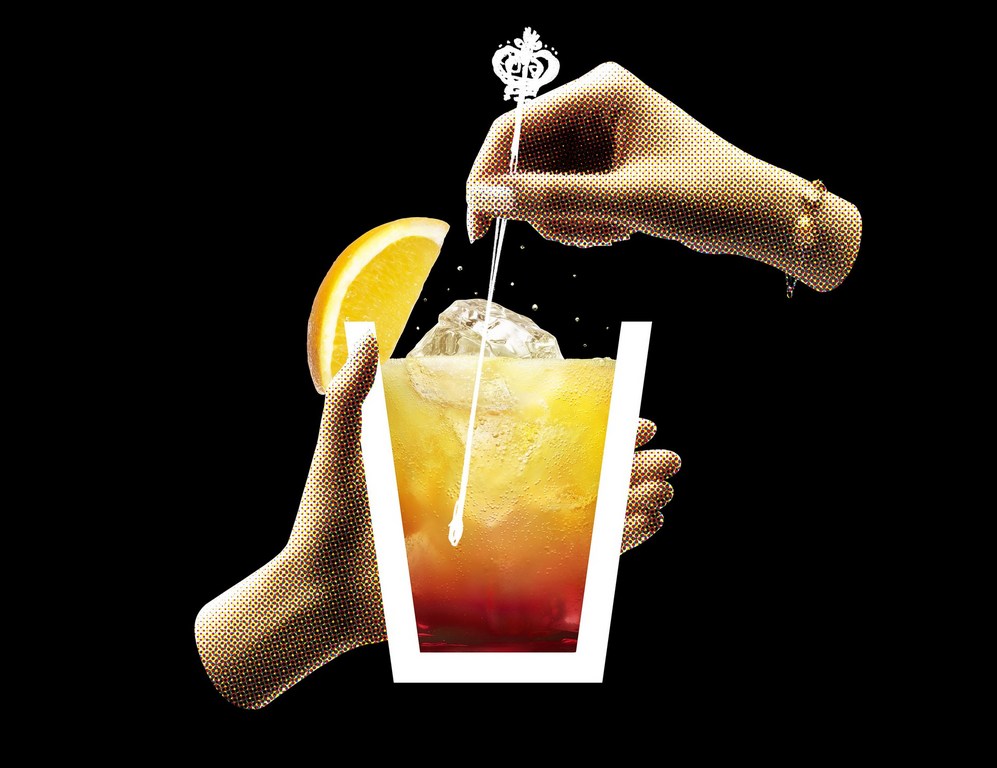 Cocktail drink with orange slice being stirred by a bar spoon held by two hands against a black background in studio photography.