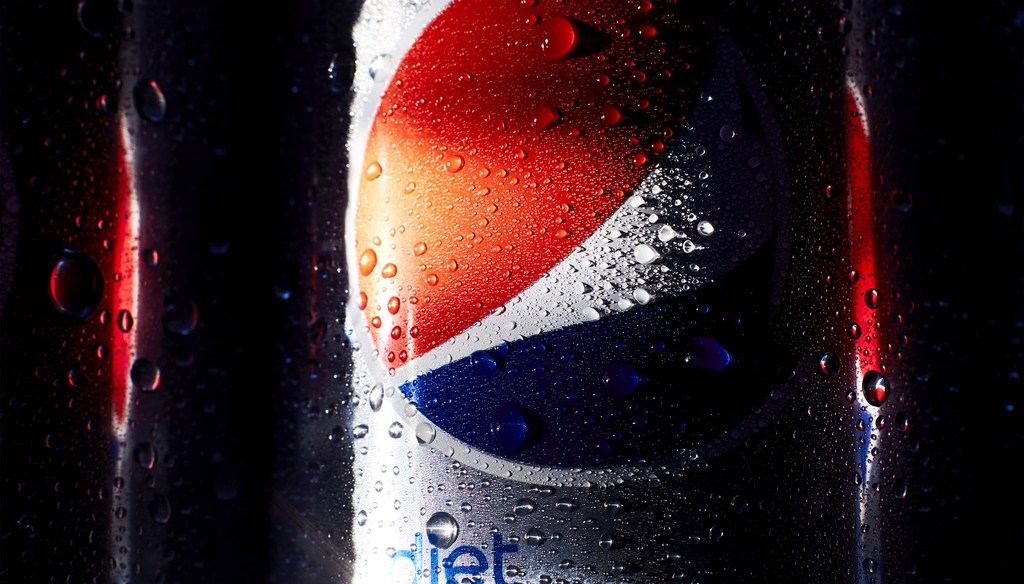 Close-up of a cold, wet can of Diet Pepsi with condensation droplets against a black background and a red light streak.