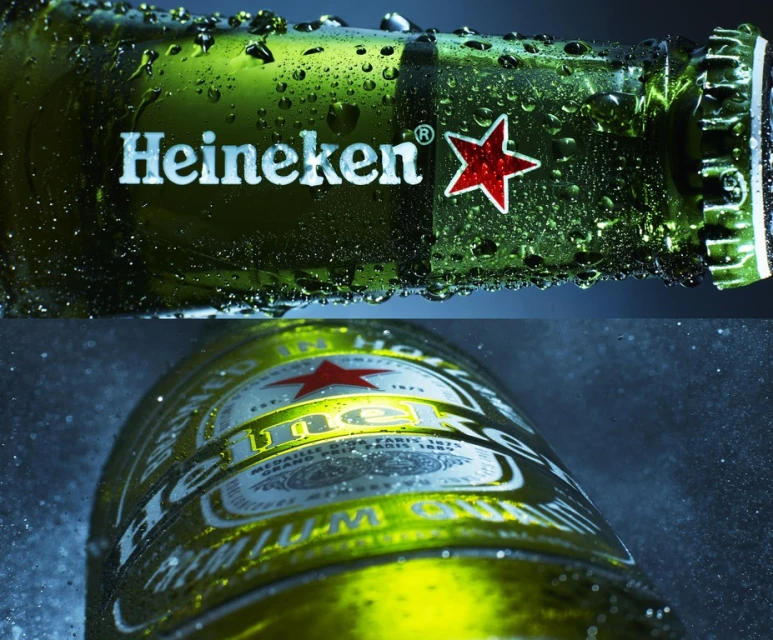 Close-up shot of a green Heineken beer bottle with condensation, featuring the brand's logo with a star against a blue background.