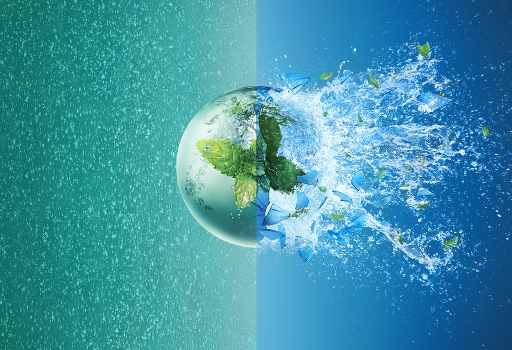 Abstract image of a sphere with mint leaves, water splashes, and fractured pieces against split green and blue backgrounds.