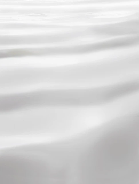 Abstract background with soft, blurry, horizontal folds of white fabric or sheet. Softly lit and shadowed. Neutral aesthetic.