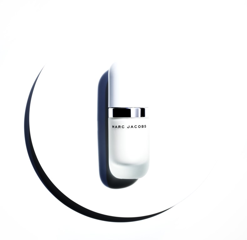 White perfume bottle with silver band and text on a circular white background with a curved shadow