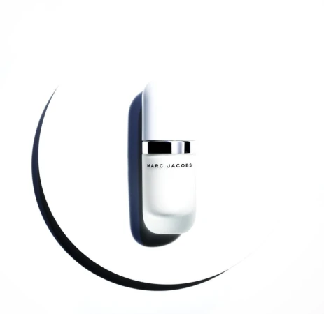White perfume bottle with silver band and text on a circular white background with a curved shadow